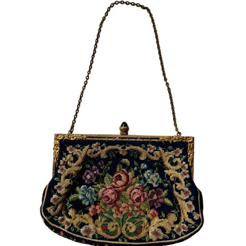 Vintage handbag with floral embroidery on a plain background
